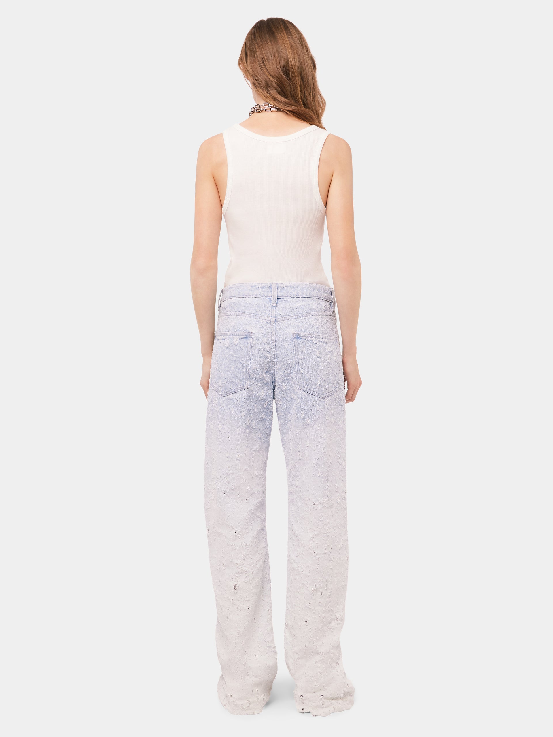 Scratched raw light blue jeans