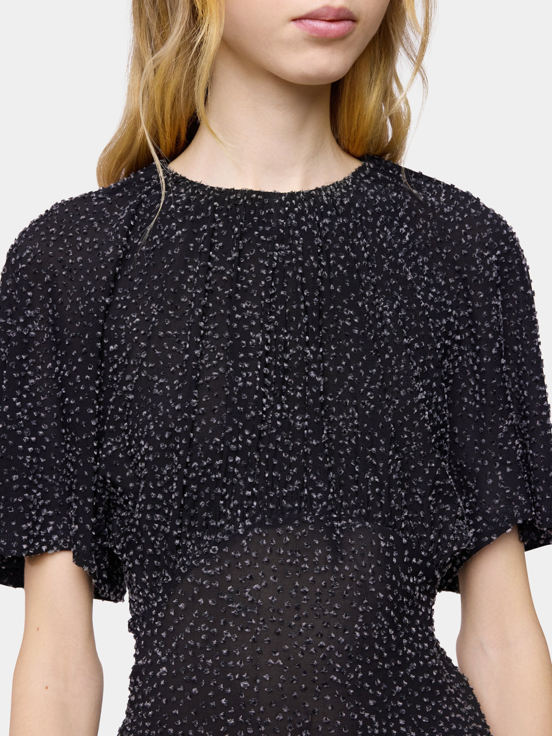 Textured asymmetrical black top with ruched details