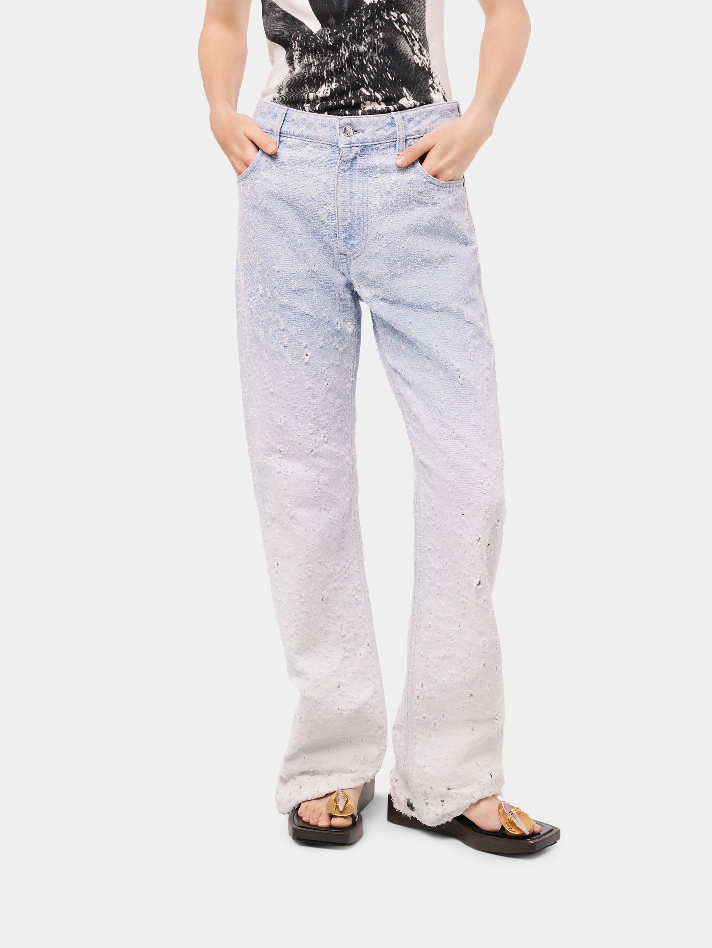Scratched raw light blue jeans