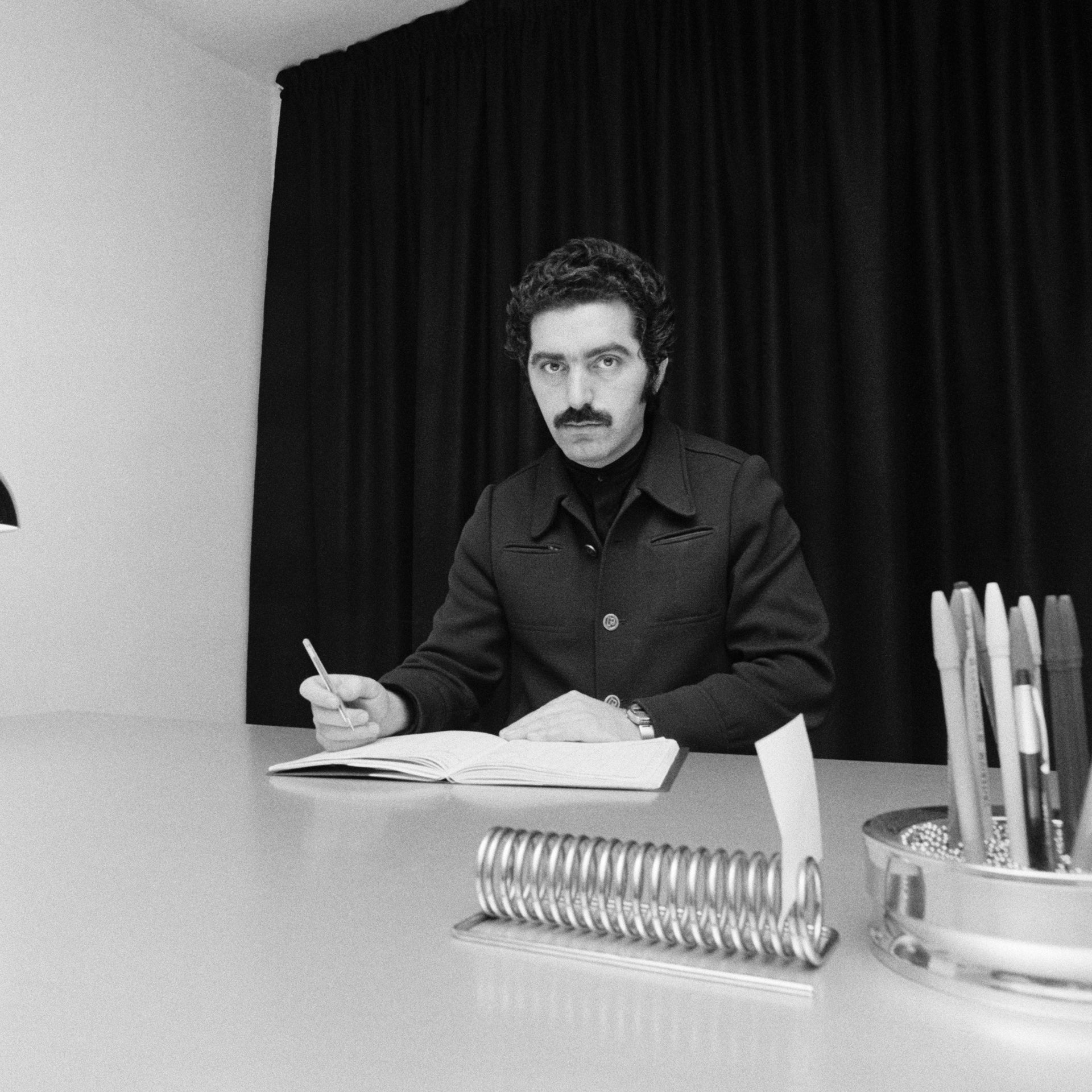 Paco Rabanne sitting at a desk